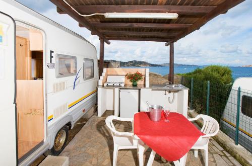 an rv with a table and chairs on a patio at Camping Acapulco in Palau