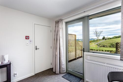 a room with a large glass door with a window at Hunters Moon in Mosgiel