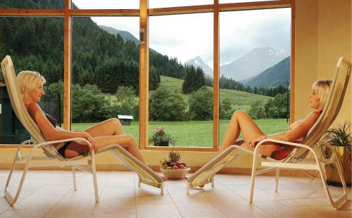 two women sitting in chairs in front of a window at Bergsporthotel Antonie in Gries im Sellrain