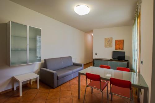 ein Wohnzimmer mit einem Sofa, einem Tisch und Stühlen in der Unterkunft Residence Corso Monferrato in Alessandria