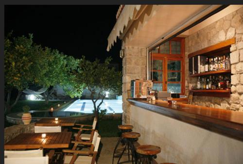 ein Restaurant mit einer Bar mit Stühlen und Tischen in der Unterkunft Villa Martha in Spetses