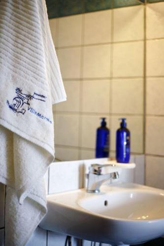 a bathroom with a sink and a white towel at Villa Martha in Spetses