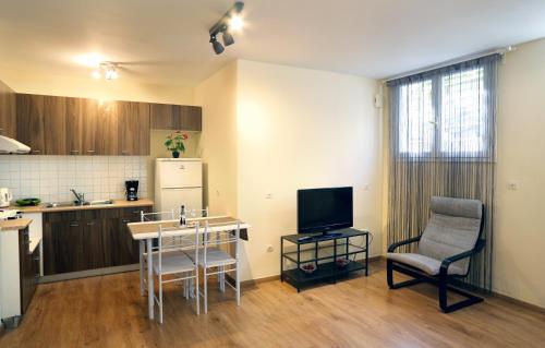 a kitchen with a table and a chair and a television at Alexandros Apartment in Athens