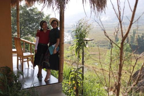 two women standing on the porch of a house at SaPa Farmer House in Sa Pa