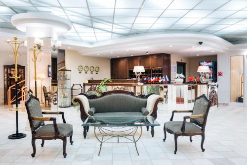 a lobby with a couch and chairs and a table at Sun Hotel in Irkutsk