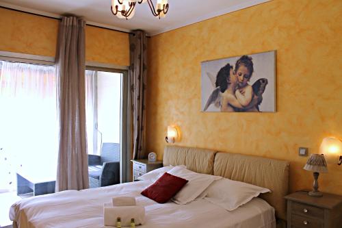 une chambre avec un lit et un tableau au mur dans l'établissement Viva Riviera Rue Victor Cousin, à Cannes