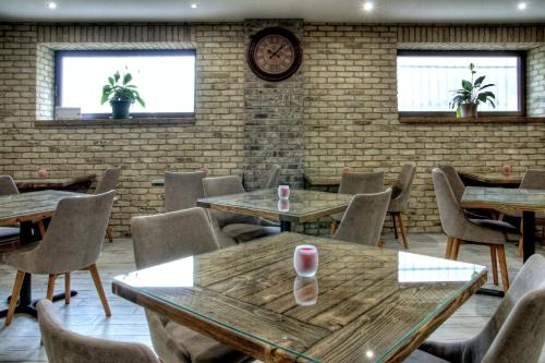 a restaurant with wooden tables and chairs and a clock at Penzión Pri Mlyne in Nitra