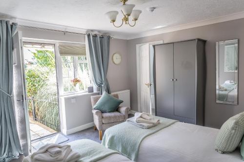 a bedroom with two beds and a chair and a window at Cricket Field House in Salisbury