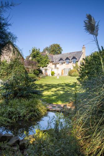 a house with a pond in front of a yard at Cricket Field House in Salisbury