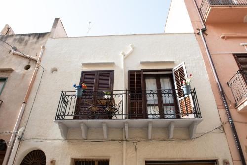 a building with a balcony with flowers on it at L' Arena Suite - Sicilian style 140 mq flat with balcony and Arena seeview in Castellammare del Golfo