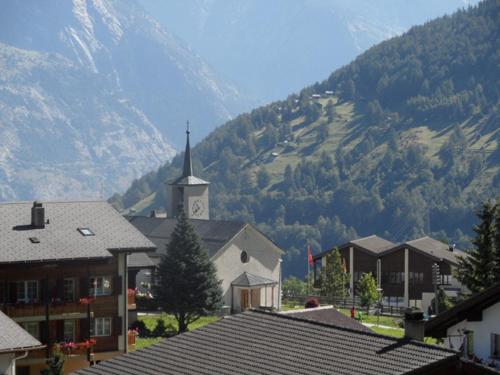 a small town with a church and a mountain at Hotel Restaurant Emshorn in Oberems