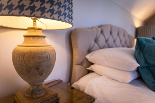 a lamp on a table next to a bed at Cricket Field House in Salisbury