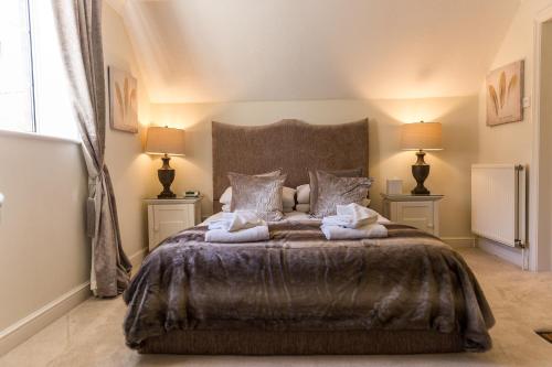 a bedroom with a large bed with two lamps at Cricket Field House in Salisbury