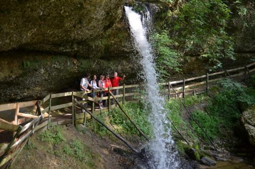 a group of people standing next to a waterfall at Hotel Alpenrose gut schlafen & frühstücken in Scheidegg