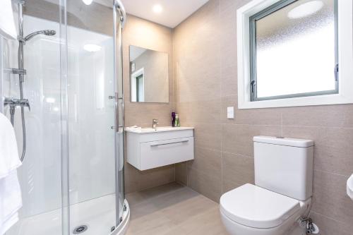 a bathroom with a shower and a toilet and a sink at Hunters Moon in Mosgiel