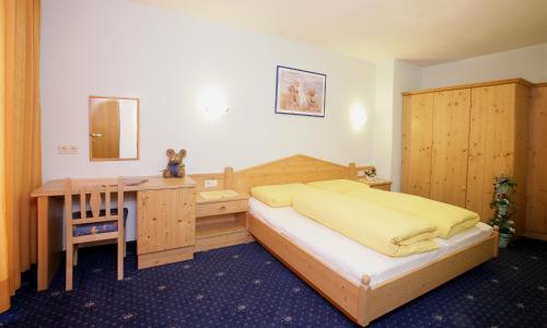 a bedroom with a bed and a desk and a table at Haus König in Obergurgl