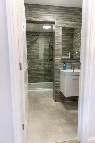 a bathroom with a shower and a sink and a mirror at Cricket Field House in Salisbury