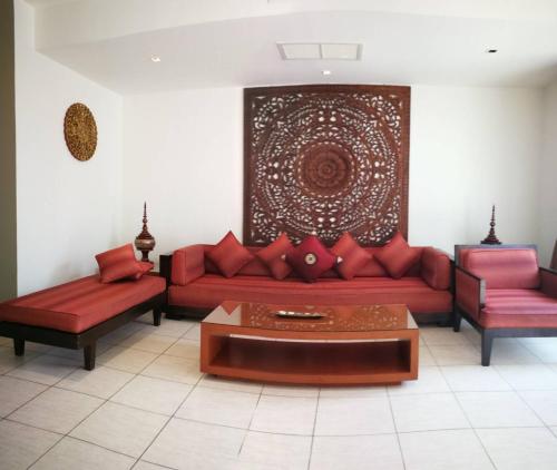 a living room with a red couch and a table at Hua Hin Blue Lagoon in Cha Am