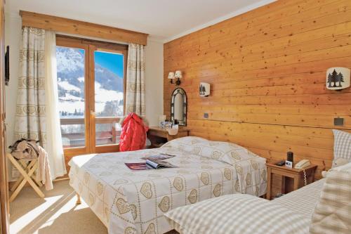 Un pat sau paturi într-o cameră la Hôtel Vacances Bleues Les Chalets du Prariand