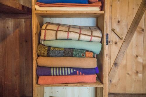 a stack of blankets on a wooden shelf at Hocheckhuette On Top of the Kitzbuehel Hahnenkamm Mountain in Kitzbühel