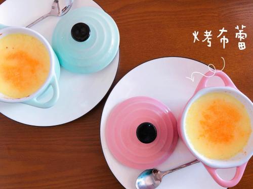 a table with two cups of coffee and a spoon at QBE B&B in Nanwan