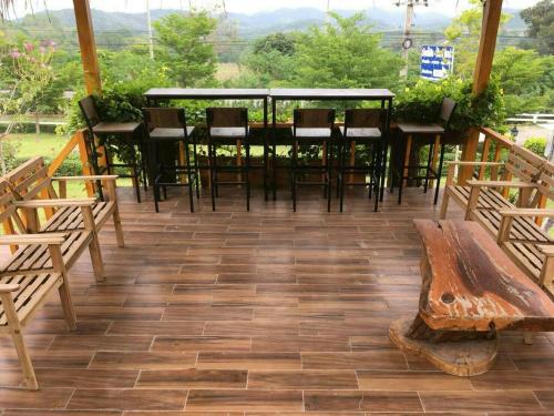 Maingern Maithong Resort في سارابوري: فناء فيه كراسي وطاولة ومقعد
