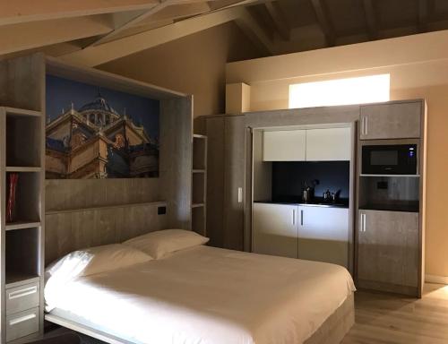 Palazzo Domanto Apartments Parma في بارما: غرفة نوم بسرير كبير ومطبخ