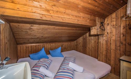 a bed in a wooden room next to a sink at Hocheckhuette On Top of the Kitzbuehel Hahnenkamm Mountain in Kitzbühel