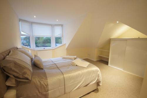 a bedroom with a bed and a window at Modern, Cosy Apartment In Bearsden with Private Parking in Glasgow