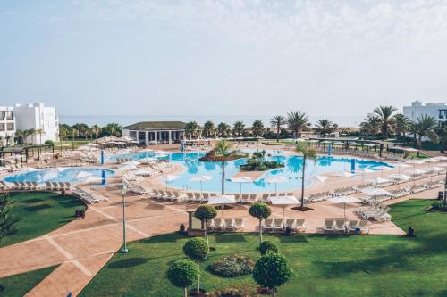 an aerial view of a resort pool with chairs and tables at Iberostar Saidia in Saidia 