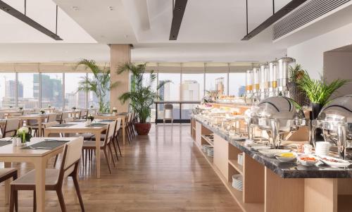 a restaurant with tables and chairs and a counter with dishes at Hotel Emion Phnom Penh in Phnom Penh