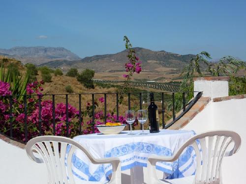 un tavolo con due sedie e una bottiglia di vino di Casa Fuente de la Zorra ad Alora