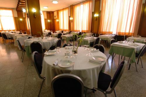 a room with tables and chairs with white tablecloths at Hotel Pere III El Gran in Vilafranca del Penedès