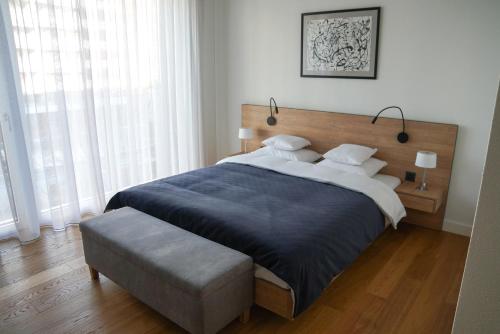 a bedroom with a large bed and a large window at Zug Downtown Apartments in Zug