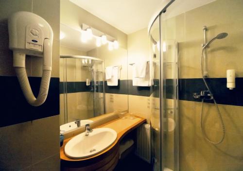 a bathroom with a shower and a sink and a shower at Hotel Atrium in Târgu Secuiesc