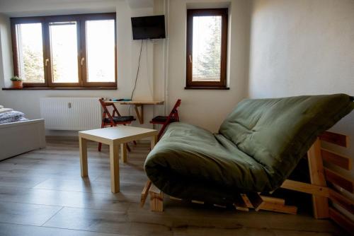 a living room with a green couch and a table at Apartments Pod Kotlom in Vysoké Tatry