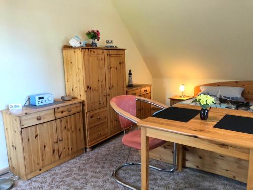 プレローにあるApartment Prerowのテーブルと木製のキャビネットが備わる客室です。