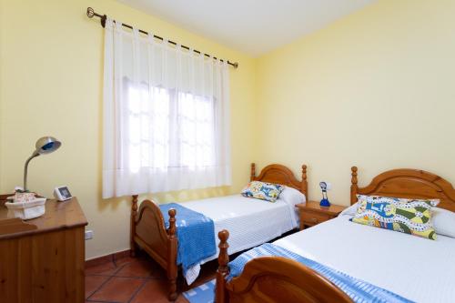 a bedroom with two beds and a window at Finca La Vizcondesa in Icod de los Vinos