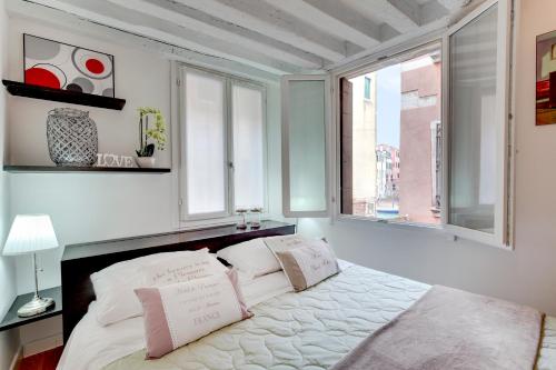 - une chambre avec un lit avec deux oreillers et une fenêtre dans l'établissement Cannaregio Canal View - Marco Polo, à Venise