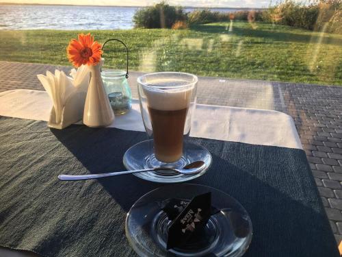 a cup of coffee sitting on a table with a plate at Žvejų užeiga in Šiauliai