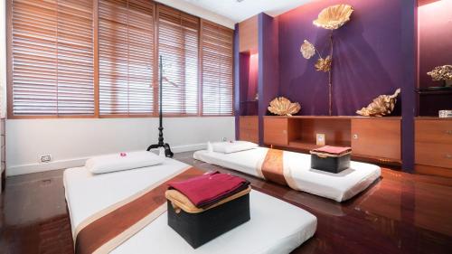 two beds in a room with purple walls at Dream Hotel Bangkok in Bangkok