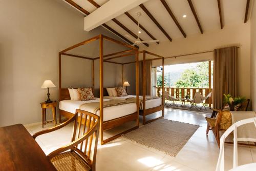 1 dormitorio con cama con dosel y balcón en Rukgala Retreat, en Digana