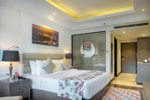 a bedroom with a large white bed and a mirror at Ramada by Wyndham Kasauli in Kasauli