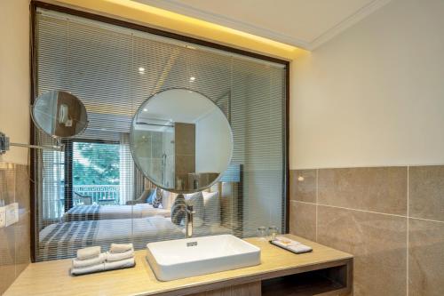 a bathroom with a sink and a mirror at Ramada by Wyndham Kasauli in Kasauli