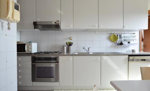 a kitchen with white cabinets and a stove top oven at sunset@leçadapalmeira in Matosinhos