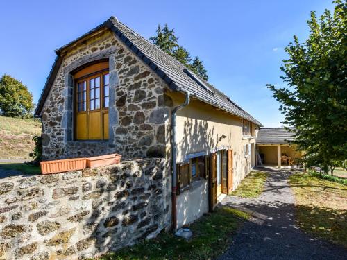 a stone house with a window on the side of it at Former farmhouse fully renovated with garden near the Auvergne volcanoes in Calvinet