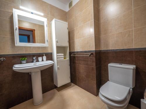 a bathroom with a toilet and a sink and a mirror at Apartamento nuevo con WiFi in Frontera