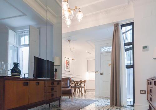 a living room with a television on a wooden dresser at Casa Timoteo Apartamentos Boutique Adults Only in Alcoy