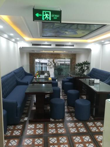 a waiting room with blue couches and a table at Golden Legend Palace Hotel & Travel in Hanoi