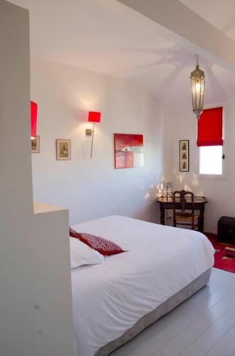a bedroom with a white bed and a table at La Ferrade Chambres d'Hôtes B&B in Bègles